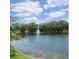 Scenic view of a tranquil pond with a fountain, surrounded by lush greenery and trees at 2722 11Th Ct # 50A, Palm Harbor, FL 34684