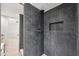 Stylish walk-in shower featuring modern gray tiles, a niche for storage, and sleek fixtures at 2722 11Th Ct # 50A, Palm Harbor, FL 34684