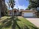 Charming single-story home featuring a well-manicured lawn, arched entryway, and attached two-car garage at 2752 Cypress Dr, Clearwater, FL 33763