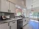 Modern kitchen featuring granite countertops, stainless steel appliances, white cabinetry, and decorative tile backsplash at 2752 Cypress Dr, Clearwater, FL 33763