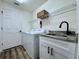 Laundry room with sink, washer, dryer, and overhead storage at 2752 Cypress Dr, Clearwater, FL 33763