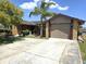 Charming single-story home featuring a two-car garage, stone accents, and a well-manicured front yard with a palm tree at 3532 Overland Dr, Holiday, FL 34691
