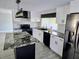 Modern kitchen with white cabinets, granite countertops, stainless steel appliances, and a kitchen island at 3532 Overland Dr, Holiday, FL 34691