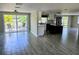 Open-concept living space with gray tile flooring and sliding glass doors with water views at 3532 Overland Dr, Holiday, FL 34691