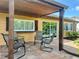 This covered patio features a patterned stone floor, yellow exterior, brown accents, and outdoor seating at 3532 Overland Dr, Holiday, FL 34691