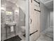 Stylish bathroom with a rustic sliding door, decorative tile, and modern fixtures at 3906 W De Leon St, Tampa, FL 33609