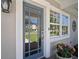 Inviting home entrance featuring a blue glass paneled door and flower accents near bright white framed windows at 3906 W De Leon St, Tampa, FL 33609