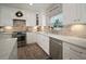 Bright kitchen features stainless steel appliances and white cabinets with updated countertops at 3906 W De Leon St, Tampa, FL 33609