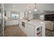 Modern, open kitchen with white cabinets, a large island, and a view into the cozy living area at 3906 W De Leon St, Tampa, FL 33609