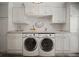 Well-organized laundry area with modern washer and dryer, custom cabinetry and countertop space at 3906 W De Leon St, Tampa, FL 33609