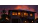 Two-story home featuring a striking sunset, complemented by awnings and manicured landscaping at 3924 N Ridge Ave, Tampa, FL 33603