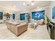 Open-concept living room with large windows, neutral toned decor, and comfortable seating arrangement at 3924 N Ridge Ave, Tampa, FL 33603