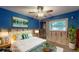 Cozy bedroom with a ceiling fan, bright blue walls, and a large window bringing in light at 4511 Huntington Ne St, St Petersburg, FL 33703