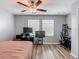 Cozy bedroom featuring wood-look floors, fan and two windows for plenty of natural light at 4624 Willet Cooper Ct, Tampa, FL 33619