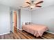 Bright bedroom with wood floors, light walls, ceiling fan, and neutral colored bedding at 4624 Willet Cooper Ct, Tampa, FL 33619