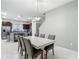 Open concept dining room with a modern light fixture and views into the kitchen and living area at 4624 Willet Cooper Ct, Tampa, FL 33619