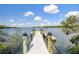 View of wooden dock with black cap railing, leading out to the open water and city skyline at 4624 Willet Cooper Ct, Tampa, FL 33619