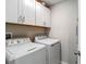 Bright laundry room with washer, dryer, and white cabinetry at 4624 Willet Cooper Ct, Tampa, FL 33619