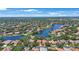 An aerial view showcases a community with homes surrounding a beautiful lake and lush green landscaping at 4815 Queen Palm Ne Ter, St Petersburg, FL 33703