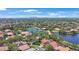 Aerial view of a neighborhood featuring lush landscaping, numerous homes, and a picturesque lake at 4815 Queen Palm Ne Ter, St Petersburg, FL 33703