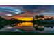 A scenic sunset reflected in a serene lake with palm trees and houses in the background at 4815 Queen Palm Ne Ter, St Petersburg, FL 33703