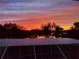 A backyard overlooking the lake with sunset views through screened-in pool area at 4815 Queen Palm Ne Ter, St Petersburg, FL 33703