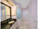 Bright bathroom featuring a sleek vanity with a black countertop and a large framed mirror at 4815 Queen Palm Ne Ter, St Petersburg, FL 33703