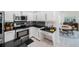 Well-lit kitchen with stainless steel appliances, black countertops, and mosaic tile backsplash at 4815 Queen Palm Ne Ter, St Petersburg, FL 33703
