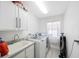 Bright laundry room with white cabinetry, a sink, and modern washer and dryer appliances at 4815 Queen Palm Ne Ter, St Petersburg, FL 33703