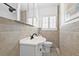 Bathroom with tile walls, white vanity, toilet, black faucet and fixtures, and a window at 4920 17Th N Ave, St Petersburg, FL 33710