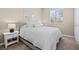 Bedroom features neutral colors, carpet, a window with blinds, a nightstand and bedside lamp at 4920 17Th N Ave, St Petersburg, FL 33710