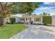 Charming single-story home with a well-manicured lawn, complemented by a mature tree and long driveway at 4920 17Th N Ave, St Petersburg, FL 33710