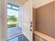 Open front door view showcasing a modern bench and a glimpse of the lush landscaping outside at 5603 Tybee Island Dr, Apollo Beach, FL 33572