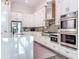 This well-equipped kitchen features stainless steel appliances, white cabinets, quartz countertops, and stylish backsplash at 5603 Tybee Island Dr, Apollo Beach, FL 33572