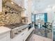 Gourmet kitchen featuring stainless steel appliances, a gas range, mosaic backsplash, and an adjacent dining area at 5603 Tybee Island Dr, Apollo Beach, FL 33572