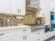Modern kitchen features stainless steel appliances, a gas range, quartz countertops, and sleek white cabinets at 5603 Tybee Island Dr, Apollo Beach, FL 33572