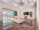 Spacious living room featuring a large sofa, media center, ceiling fan, and an outdoor pool and patio area at 5603 Tybee Island Dr, Apollo Beach, FL 33572