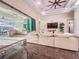 Bright living room featuring tile floors, modern lighting, outdoor kitchen, and oversized couch for relaxing and entertaining at 5603 Tybee Island Dr, Apollo Beach, FL 33572