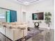 Bright living room with a large sofa, media center, and access to the outdoor pool area with a covered patio at 5603 Tybee Island Dr, Apollo Beach, FL 33572