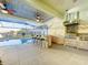 Spacious outdoor kitchen with stainless steel appliances and seating overlooking a pool and waterfront view at 5603 Tybee Island Dr, Apollo Beach, FL 33572