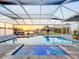 Inviting screened-in pool and spa area with scenic views of the canal at sunset at 5603 Tybee Island Dr, Apollo Beach, FL 33572