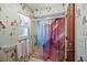 Bathroom with a shower, colorful curtain, and floral wallpaper at 588 Bayview Dr, Longboat Key, FL 34228