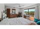 Large bedroom with a ceiling fan, dresser, a desk, and sliding glass doors to the balcony at 588 Bayview Dr, Longboat Key, FL 34228