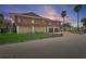 Two-story home with brown wood paneling, two-car garage, and well-maintained lawn under a colorful sky at 588 Bayview Dr, Longboat Key, FL 34228