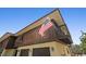 Two-story home featuring brown siding, a balcony, and an American flag on a sunny day at 588 Bayview Dr, Longboat Key, FL 34228