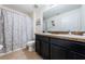 Bathroom with double sink vanity, tile flooring, framed mirror, and neutral floral shower curtain at 5928 81St N Ave, Pinellas Park, FL 33781