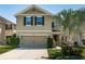 Inviting two-story home with a neutral exterior, large garage door, and manicured front lawn at 5928 81St N Ave, Pinellas Park, FL 33781