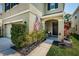 Charming front porch with an American flag, dark door, dark mulch beds, and manicured green bushes at 5928 81St N Ave, Pinellas Park, FL 33781
