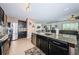 Island kitchen featuring granite counters, black cabinets, and stainless steel appliances in an open layout at 5928 81St N Ave, Pinellas Park, FL 33781