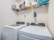 Laundry room showcasing white front load washer and dryer with wire shelf and storage supplies above at 5928 81St N Ave, Pinellas Park, FL 33781